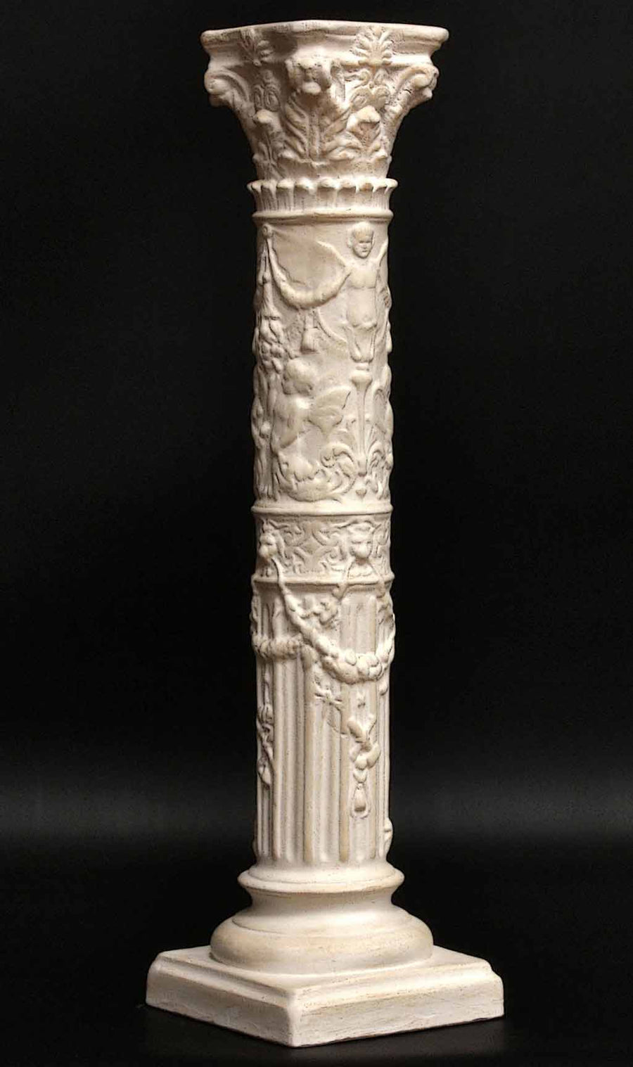 photo of plaster cast of ornamental ivory-color candlestick with black background