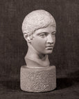 black and white photo of white plaster cast head of male on gray background