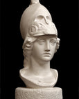 photo of plaster cast sculpture bust of female head, namely the goddess Athena, with a helmet on a black background