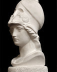 photo of plaster cast sculpture bust of female head, namely the goddess Athena, with a helmet on a black background