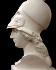 photo of plaster cast sculpture bust of female head, namely the goddess Athena, with a helmet on a black background