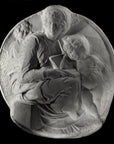 photo of plaster cast sculpture relief of the Madonna sitting with the baby Jesus beside her leaning on a book on her lap on a black background