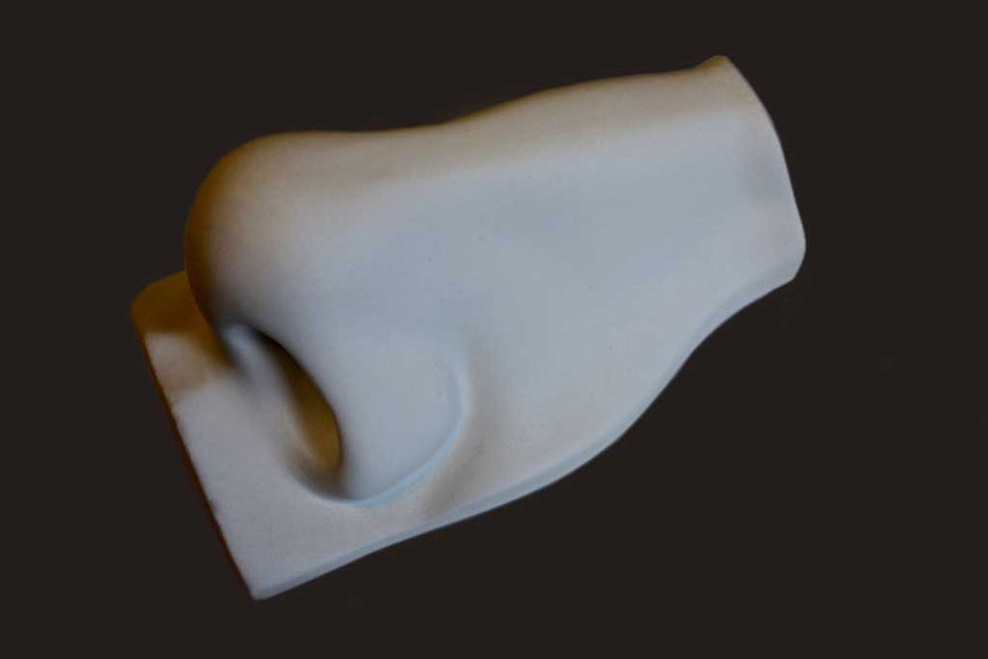 Photo of plaster cast sculpture of nose from Michelangelo's David statue on a black background