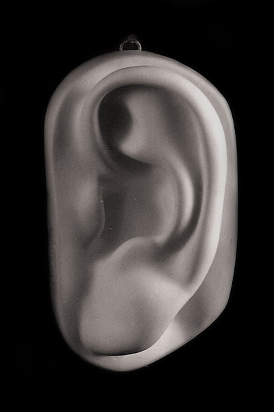 Photo of plaster cast sculpture of left ear from Michelangelo's David statue on a black background
