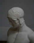photo of plaster cast of sculpture of nude male, namely the god Ares, without arms and wearing a helmet on a gray background