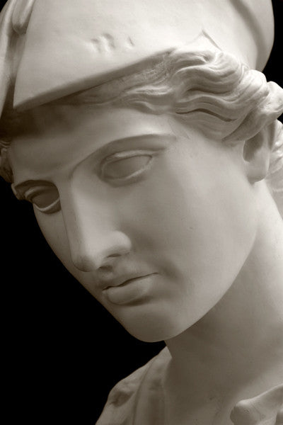 photo of plaster cast sculpture bust of female head, namely the goddess Minerva, with a helmet and looking down with black background
