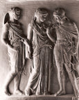 photo with gray background of plaster cast of ancient relief with three figures, namely Hades, Eurydice, and Orpheus