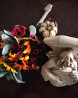 photo of plaster cast sculpture of architectural bracket on a dark table next to fall flowers and a pumpkin