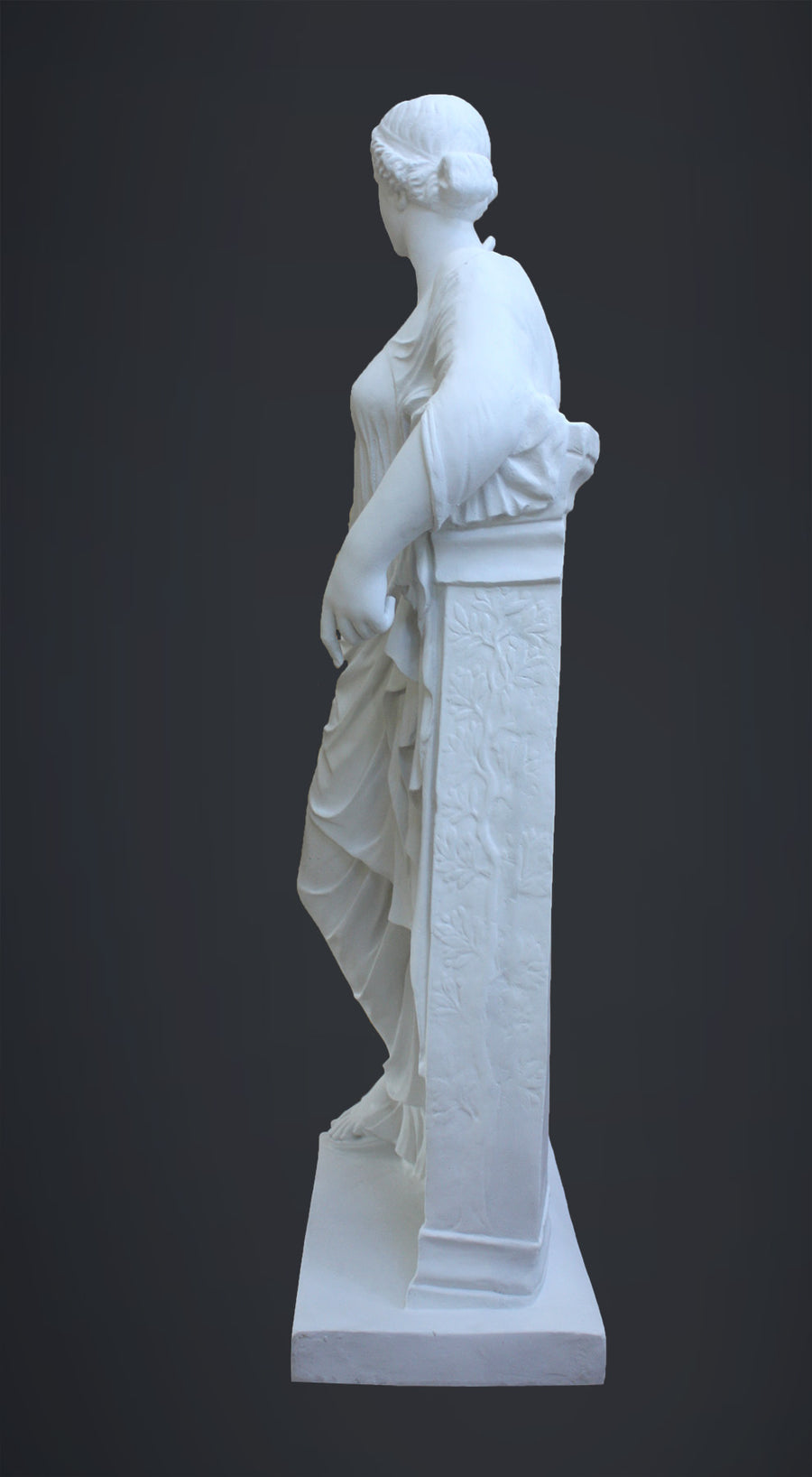 photo of plaster cast sculpture of female figure in robes leaning on podium