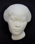 Photo of plaster cast of face of Chinese female on a black background