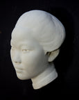 Photo of plaster cast of face of Chinese female, profile view, on a black background