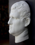 Photo of plaster cast sculpture reproduction of an Ancient Roman mask of Agrippa, 3/4 view, on a black background