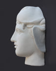 profile photo of white plaster cast of ancient sculpture of head, namely Omphale or Hercules, wearing Nemean lion skin against dark gray background