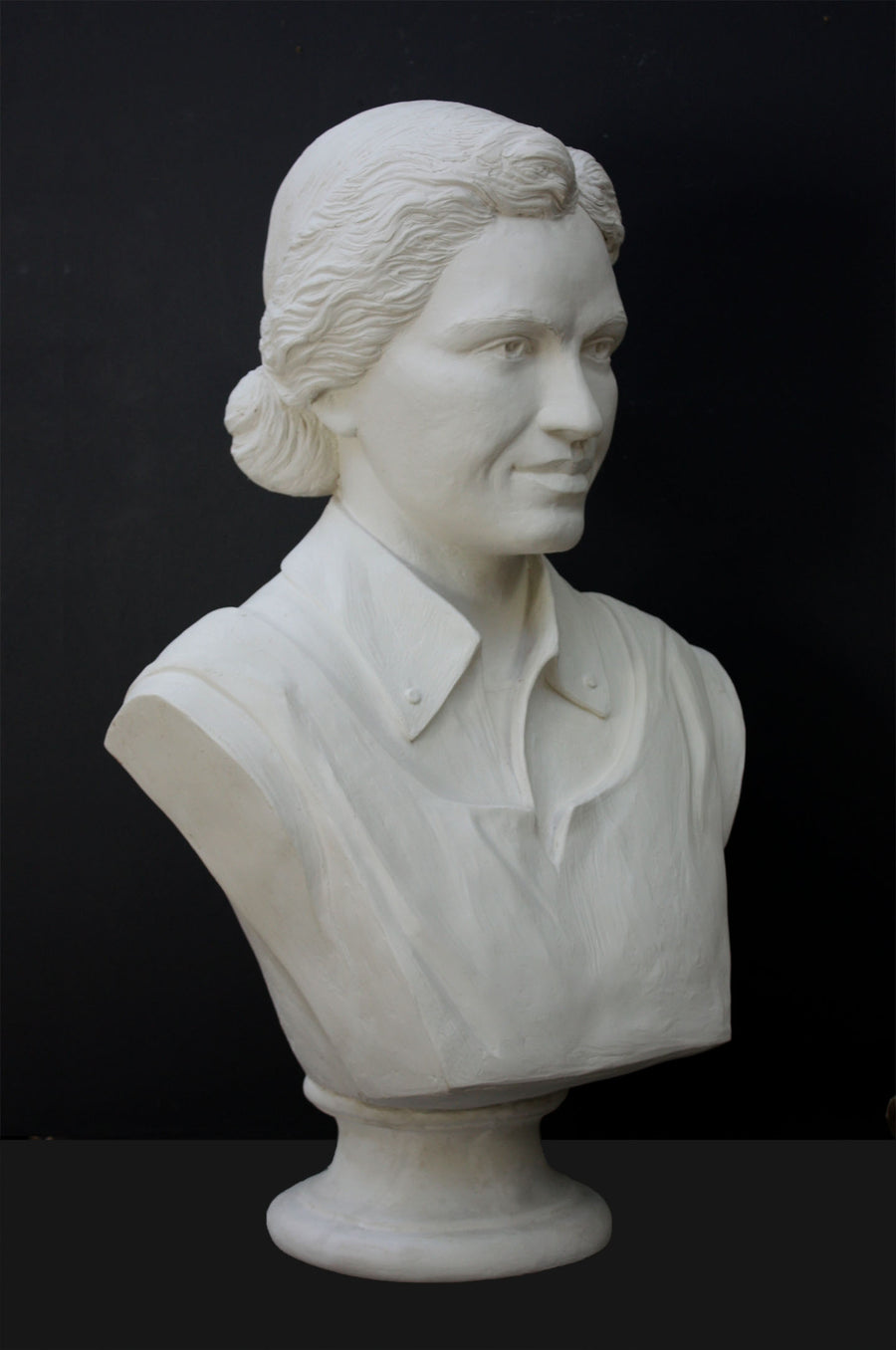 Photo of plaster cast of sculpture bust of Rosa Parks on a black background