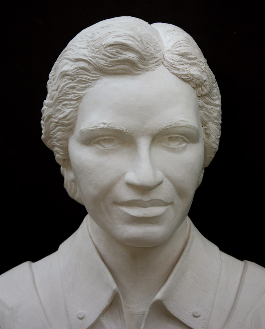 Photo of plaster cast of sculpture bust of Rosa Parks on a black background, closeup of face