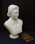 Photo of plaster cast of sculpture bust of Rosa Parks on a black background with two books sitting on the right side