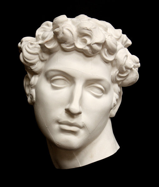 photo of white plaster cast mask of  sculpture of head, namely Giuliano de Medici, on a black background