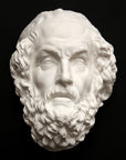 Photo of a white plaster cast mask from a sculpture of Homer on a black background