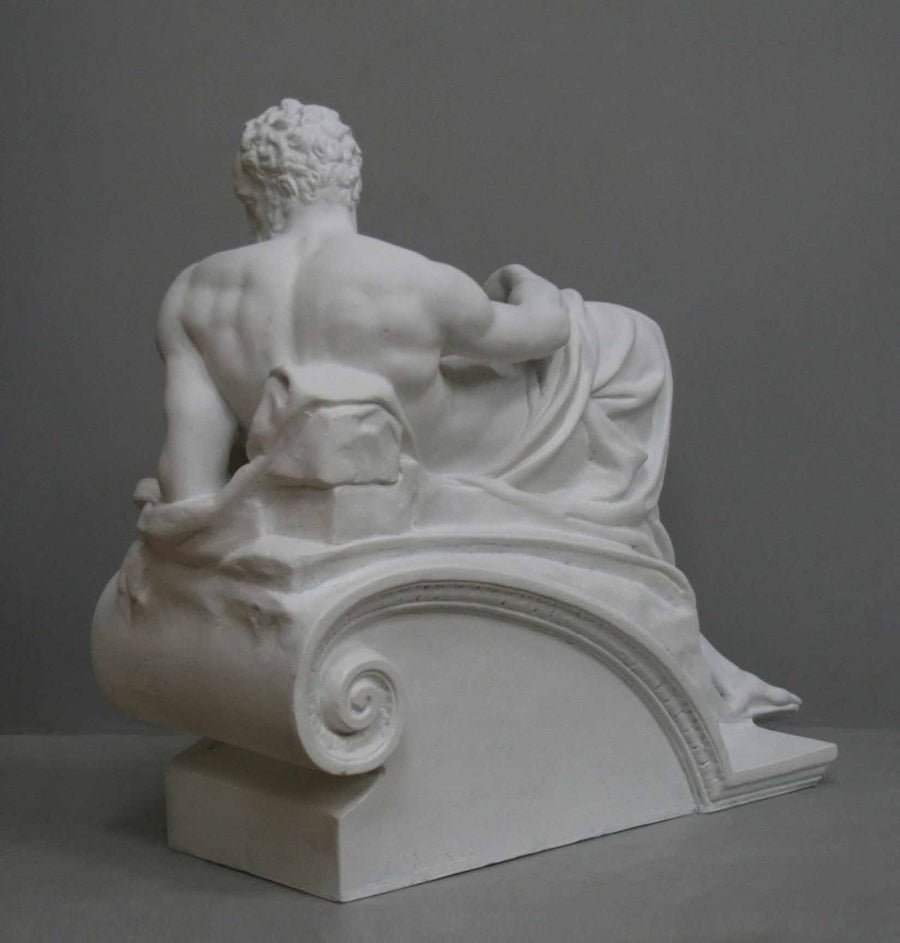 back view photo of plaster cast of reclining male nude with a gray background