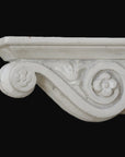 photo with black background of plaster cast of architectural bracket with scroll design