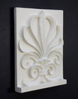 Photo of plaster cast of an Anthemion leaf palm design, 3/4 view, on a black background