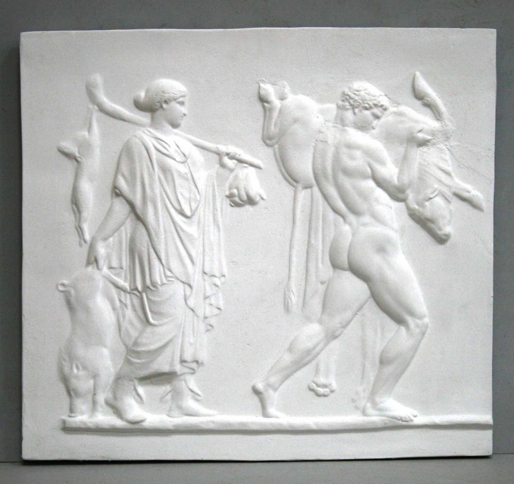 photo of plaster cast sculpture relief with two figures walking towards the right, the male, Hercules, carrying a boar, and the female carrying