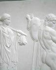 cropped photo of relief plaster cast with two figures walking towards the right