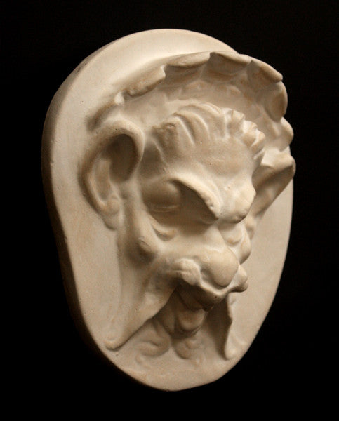 Photo of the side of a plaster sculpture of a Faun Head on a black background