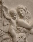 detail photo of plaster cast relief of female with wings flying and a cherub on her back on black background