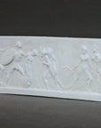 photo with gray background of plaster cast of small ancient relief sculpture with figures