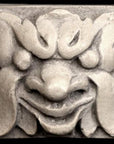 Photo of square tile sculpture of happy face made of leaves