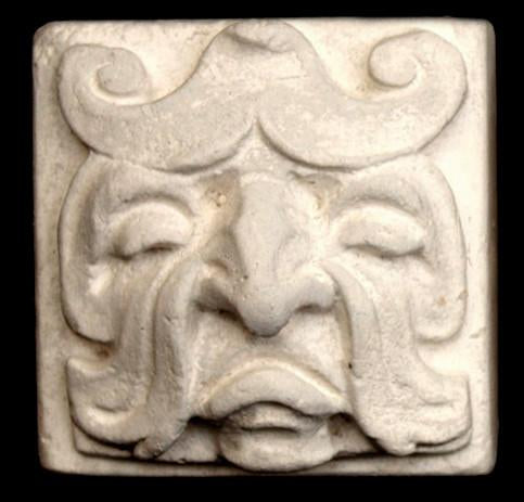 Photo of square tile sculpture of sad face made of leaves