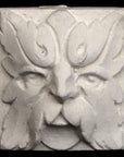 Photo of square tile sculpture of face made of leaves