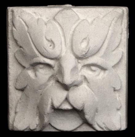 Photo of square tile sculpture of face made of leaves
