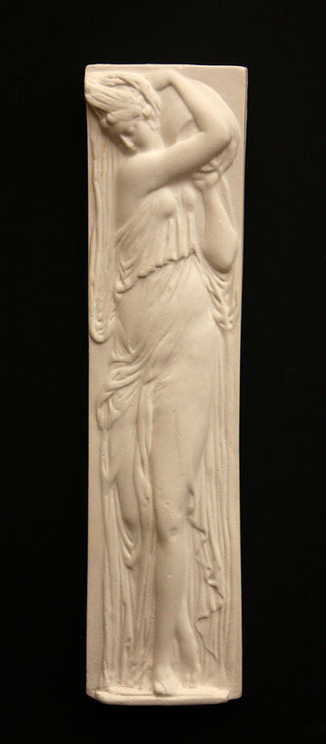 photo of plaster cast relief sculpture of female in drapery carrying jug over shoulder against black background