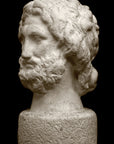 Photo with black background of plaster cast sculpture of male bust, namely the god Zeus, with curly hair and beard