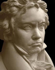 closeup photo of plaster cast sculpture of male bust of Ludwig van Beethoven in dress coat and ruffled necktie on black background