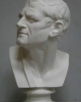 photo of plaster cast bust of man with head turned to his right and a sash on his right shoulder on a gray background