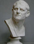 photo of plaster cast bust of man with head turned to his right and a sash on his right shoulder on a gray background