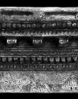 Photo with black background of plaster cast of ornamental architectural detail