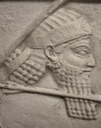 closeup photo of plaster cast relief sculpture of King Ashurbanipal on horseback and aiming an arrow in front of him