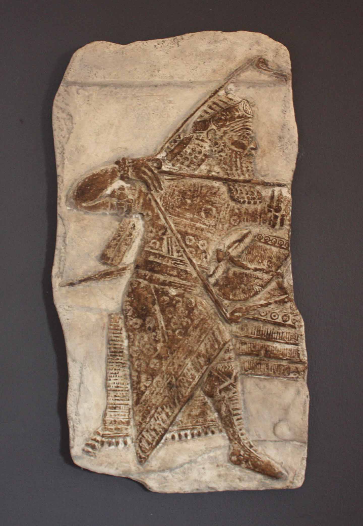 Photo of plaster cast sculpture of ancient sculpture relief on a gray background