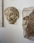 Photo of plaster cast sculpture of ancient sculpture relief and plaster casts of other sculptures on a white gallery wall