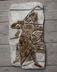 Photo of plaster cast sculpture of ancient sculpture relief on a wooden wall