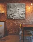Photo of plaster cast relief sculpture of men on horses from Parthenon Frieze on brick wall with table and chairs on right and bar on left, cropped