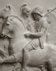 closeup photo of plaster cast relief sculpture showing three men on horses against black background
