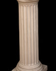photo of white plaster cast pedestal in the Doric style with a fluted column against a black background