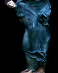image of a polychromed plaster statue of a dancer with flowing drapery on a black background