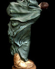 image of a polychromed plaster statue of a dancer with flowing drapery on a black background