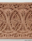 photo of plaster casts of architectural ornament with geometric lines and leaf patterns in terracotta color against white background